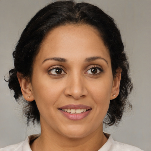 Joyful latino adult female with medium  brown hair and brown eyes