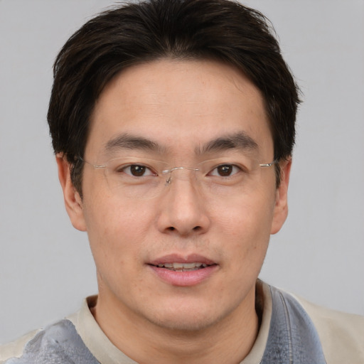 Joyful asian young-adult male with short  brown hair and brown eyes