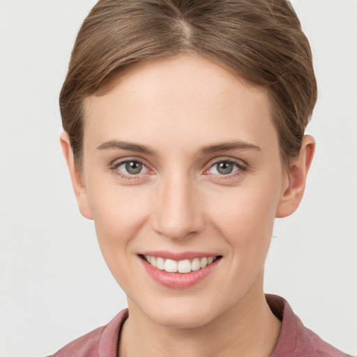 Joyful white young-adult female with short  brown hair and grey eyes