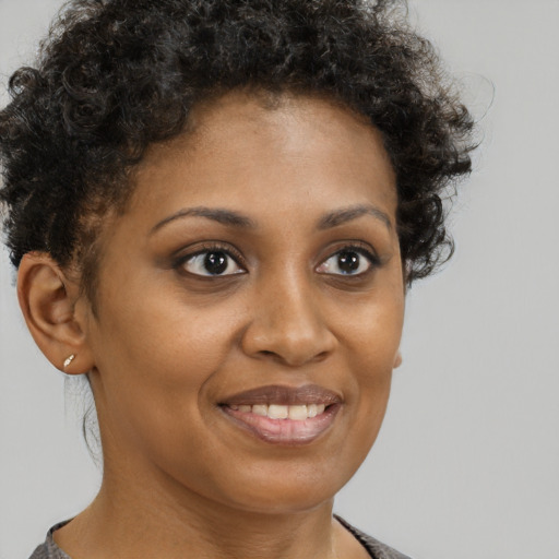 Joyful black young-adult female with short  brown hair and brown eyes