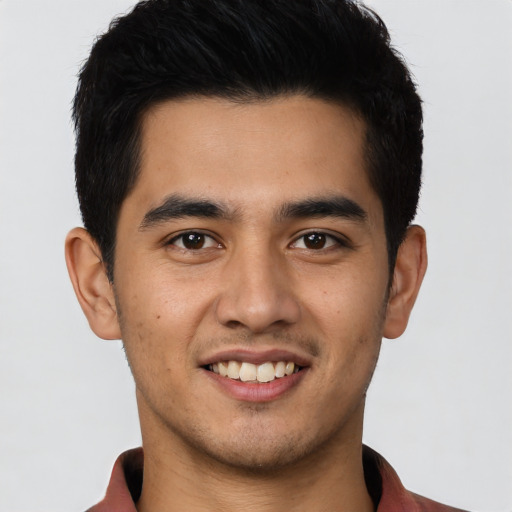 Joyful latino young-adult male with short  black hair and brown eyes