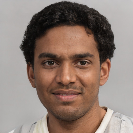 Joyful black young-adult male with short  black hair and brown eyes