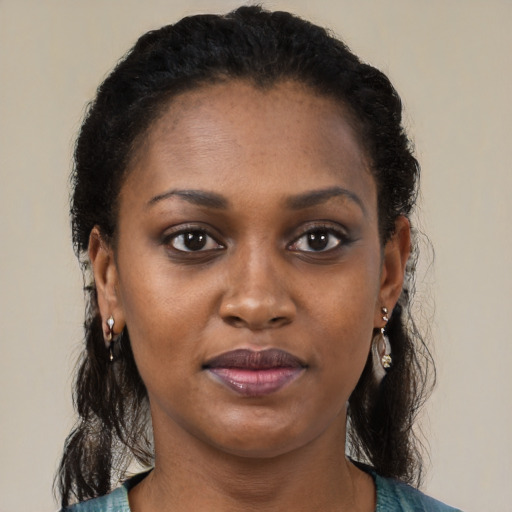 Joyful black young-adult female with long  brown hair and brown eyes