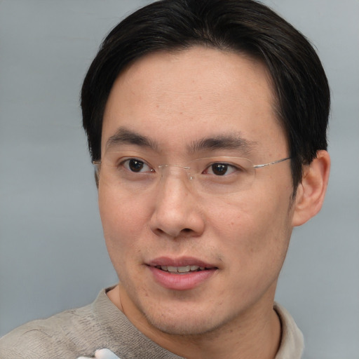 Joyful asian young-adult male with short  brown hair and brown eyes