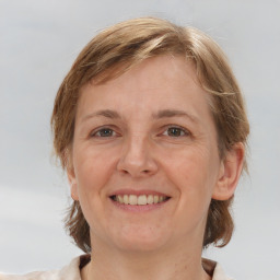 Joyful white adult female with medium  brown hair and grey eyes