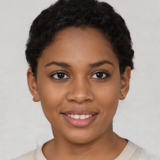 Joyful black young-adult female with short  brown hair and brown eyes
