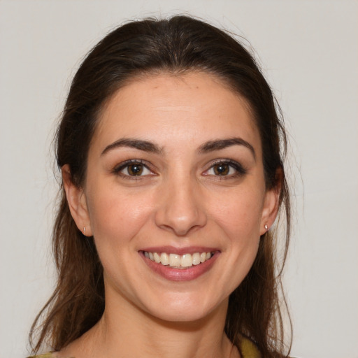 Joyful white young-adult female with long  brown hair and brown eyes