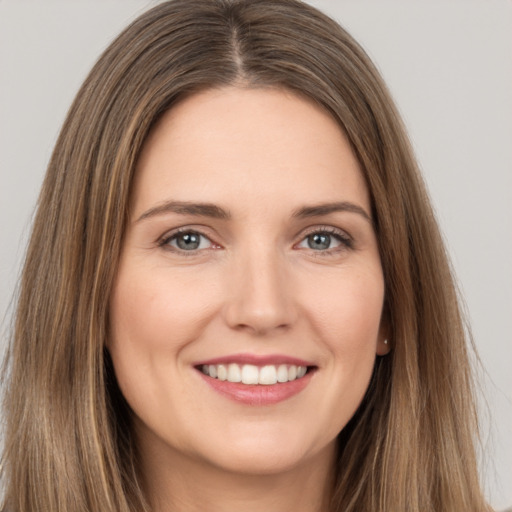 Joyful white young-adult female with long  brown hair and brown eyes