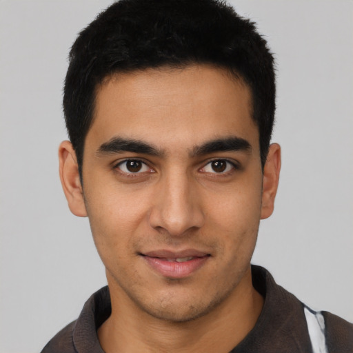 Joyful latino young-adult male with short  black hair and brown eyes