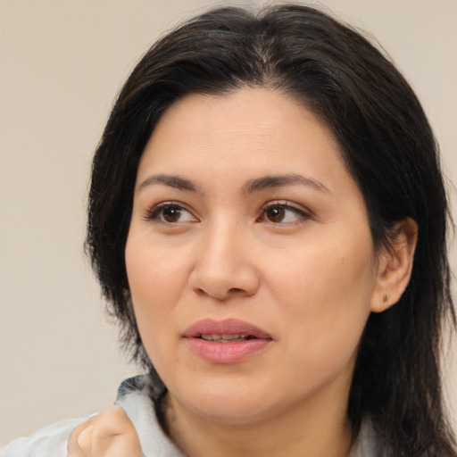 Joyful latino adult female with medium  brown hair and brown eyes