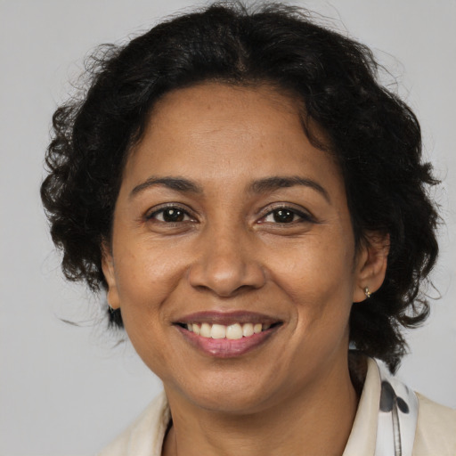 Joyful black adult female with medium  brown hair and brown eyes