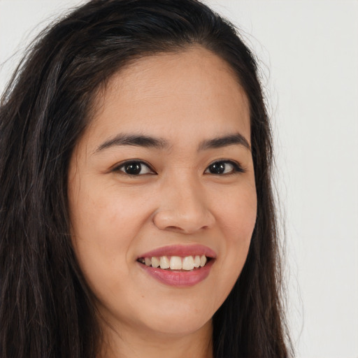 Joyful latino young-adult female with long  brown hair and brown eyes