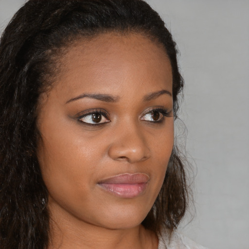 Joyful black young-adult female with long  brown hair and brown eyes