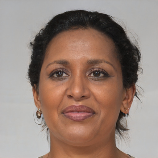 Joyful black adult female with medium  brown hair and brown eyes