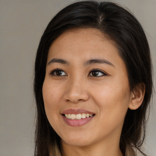 Joyful asian young-adult female with long  brown hair and brown eyes