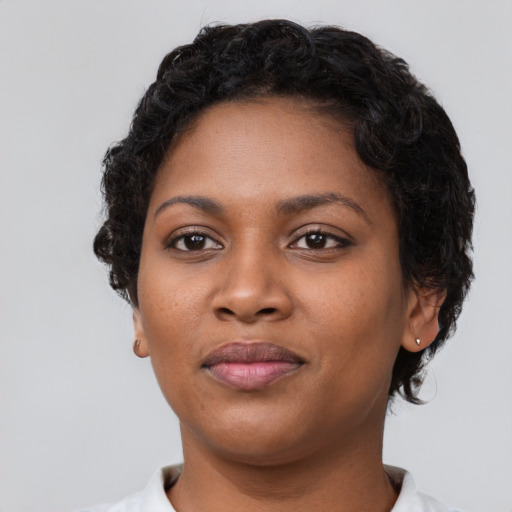 Joyful black young-adult female with short  black hair and brown eyes