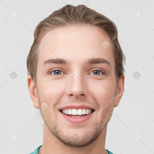 Joyful white young-adult male with short  brown hair and grey eyes