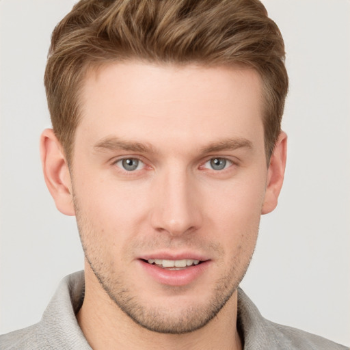 Joyful white young-adult male with short  brown hair and grey eyes