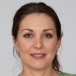 Joyful white adult female with medium  brown hair and grey eyes