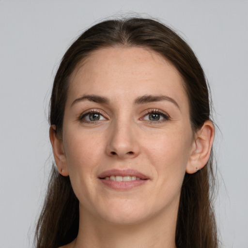 Joyful white young-adult female with long  brown hair and grey eyes