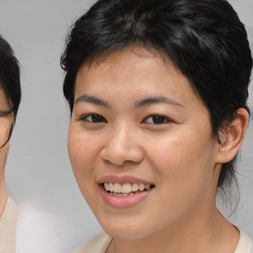 Joyful asian young-adult female with medium  brown hair and brown eyes