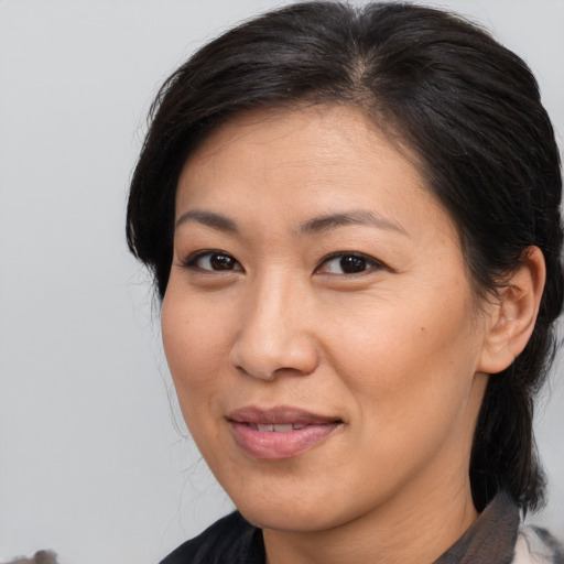 Joyful asian adult female with medium  brown hair and brown eyes