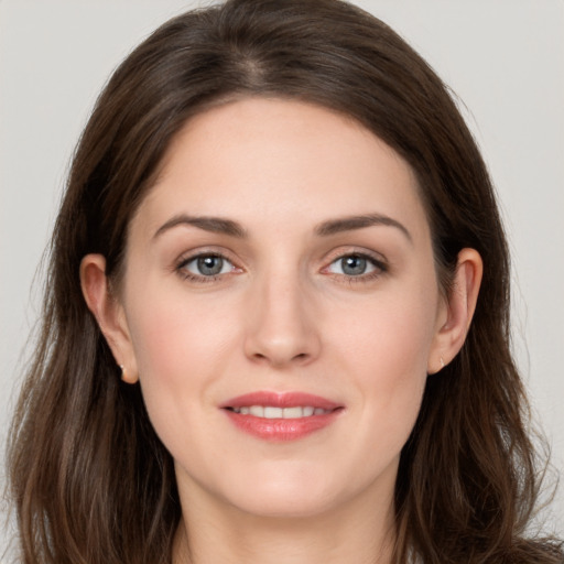 Joyful white young-adult female with long  brown hair and grey eyes