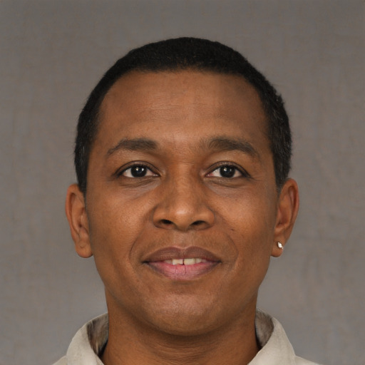 Joyful black young-adult male with short  brown hair and brown eyes