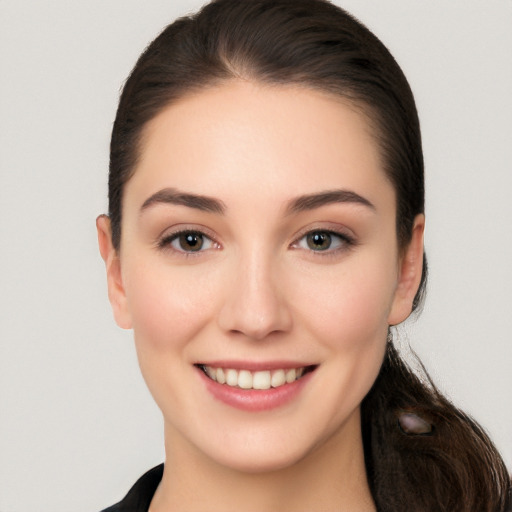 Joyful white young-adult female with long  brown hair and brown eyes