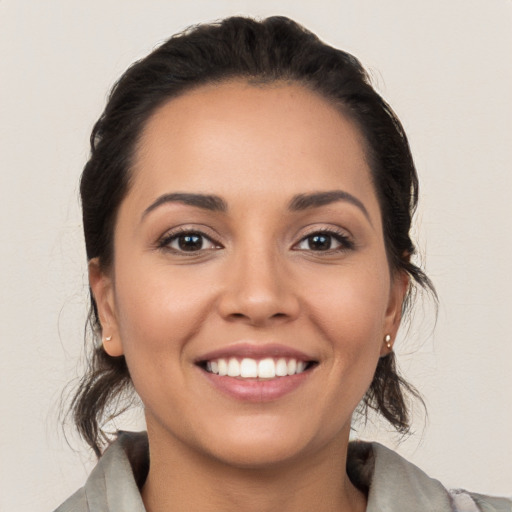 Joyful white young-adult female with medium  black hair and brown eyes