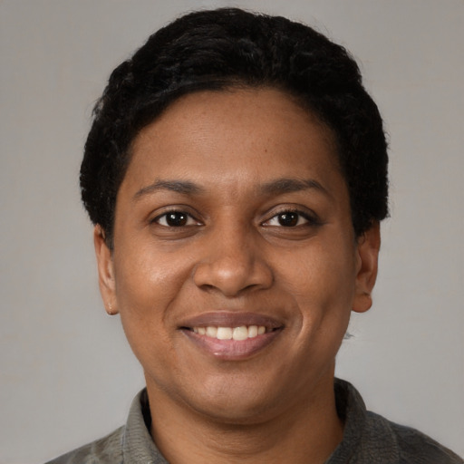 Joyful black young-adult female with short  black hair and brown eyes