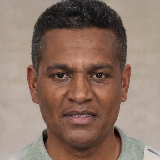 Joyful black adult male with short  brown hair and brown eyes