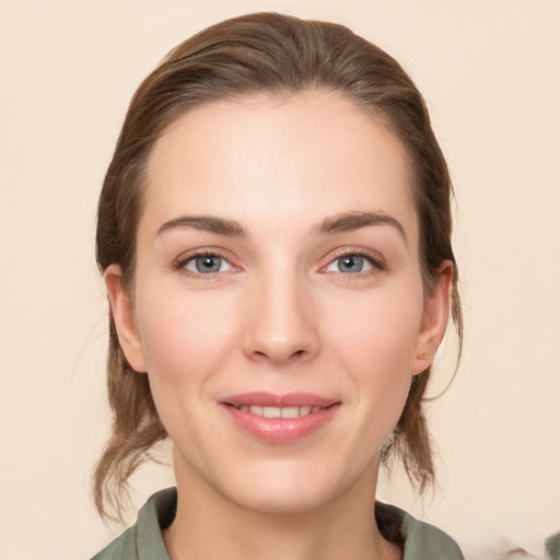 Joyful white young-adult female with medium  brown hair and grey eyes