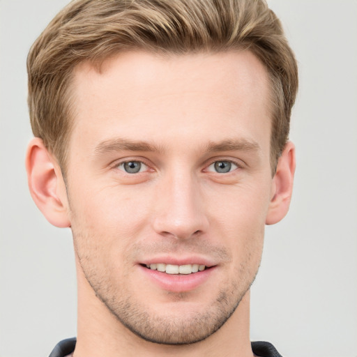 Joyful white young-adult male with short  brown hair and grey eyes