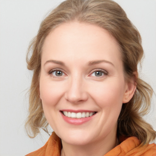 Joyful white young-adult female with medium  brown hair and blue eyes