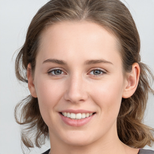 Joyful white young-adult female with medium  brown hair and blue eyes