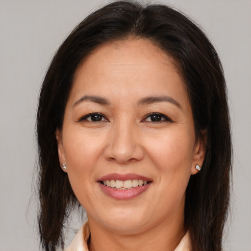 Joyful latino adult female with medium  brown hair and brown eyes