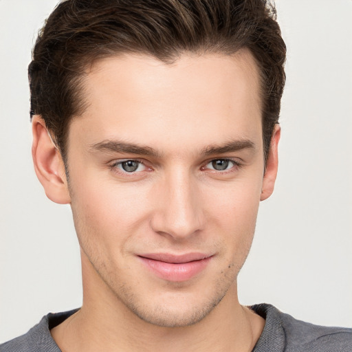 Joyful white young-adult male with short  brown hair and grey eyes