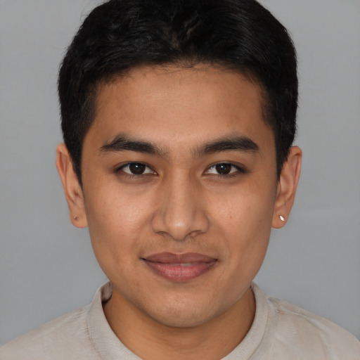 Joyful latino young-adult male with short  brown hair and brown eyes