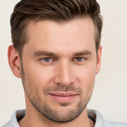 Joyful white young-adult male with short  brown hair and grey eyes