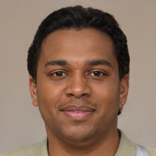 Joyful black young-adult male with short  brown hair and brown eyes