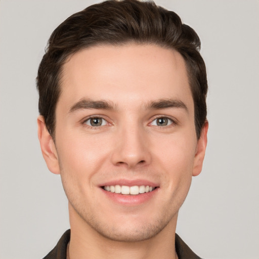 Joyful white young-adult male with short  brown hair and grey eyes