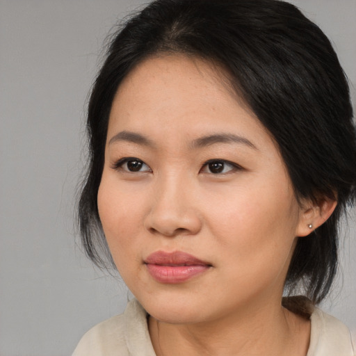 Joyful asian young-adult female with medium  black hair and brown eyes
