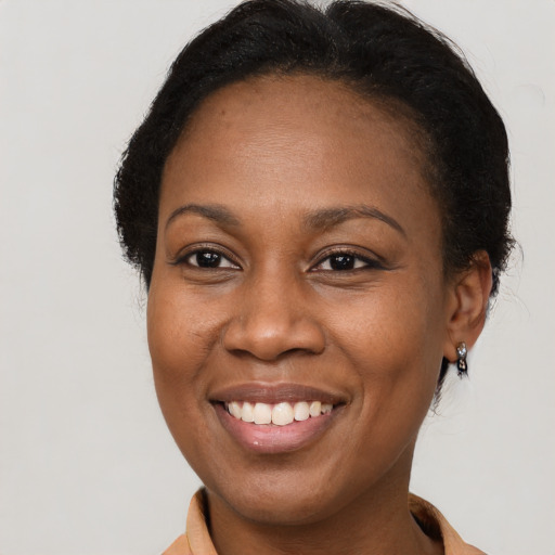 Joyful black adult female with long  brown hair and brown eyes