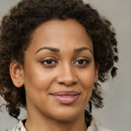 Joyful black young-adult female with medium  brown hair and brown eyes