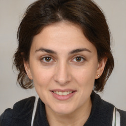 Joyful white adult female with medium  brown hair and brown eyes