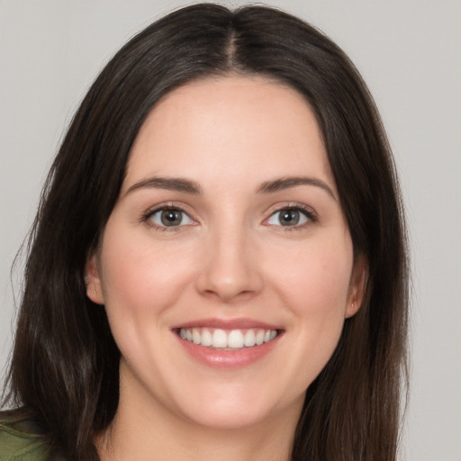 Joyful white young-adult female with long  brown hair and brown eyes