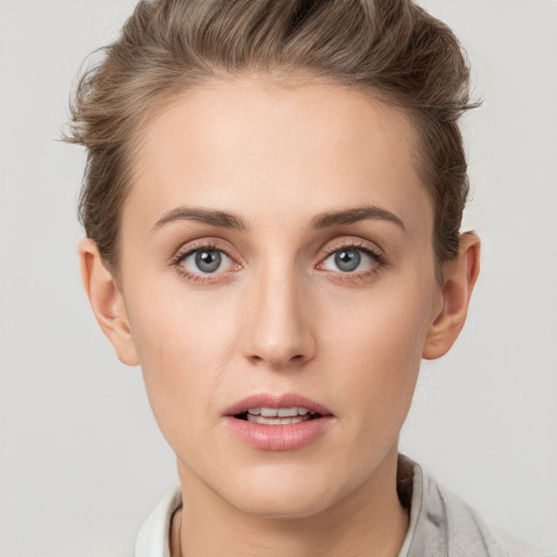 Joyful white young-adult female with short  brown hair and grey eyes