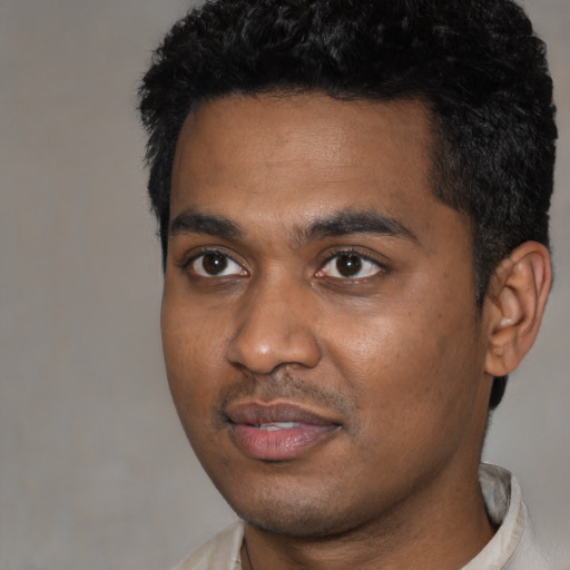Joyful black young-adult male with short  black hair and brown eyes