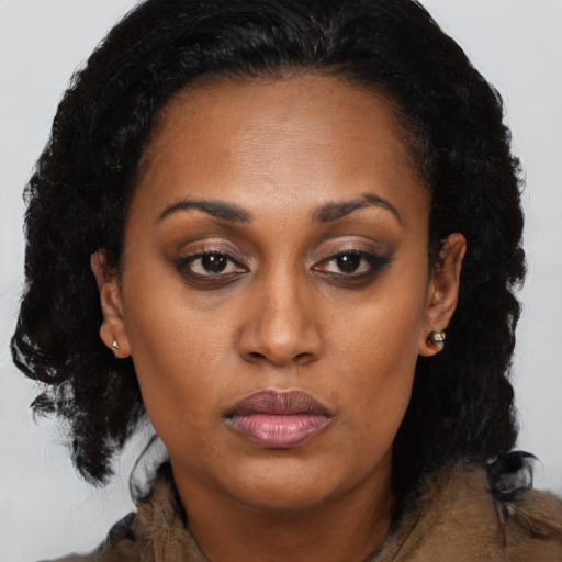 Joyful black young-adult female with medium  brown hair and brown eyes